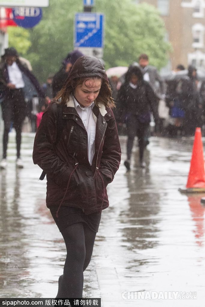 英國(guó)倫敦雨天狂風(fēng)大作 民眾出行雨傘被吹翻