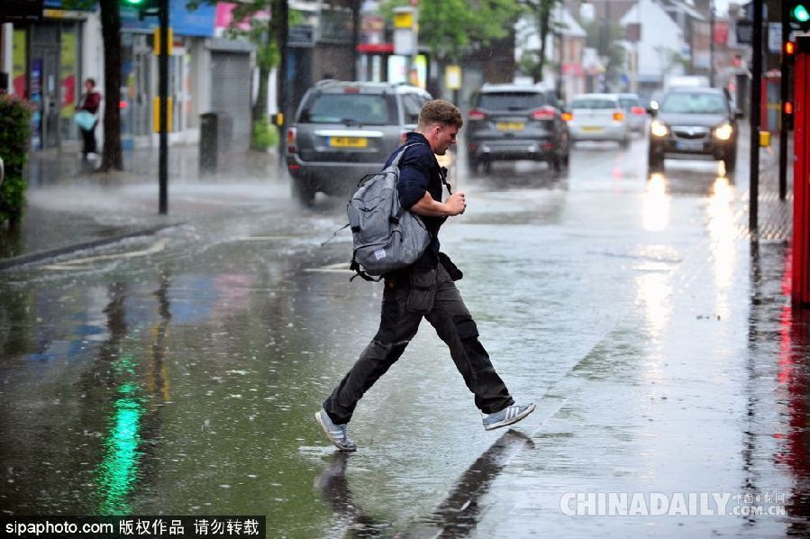 英國(guó)倫敦雨天狂風(fēng)大作 民眾出行雨傘被吹翻