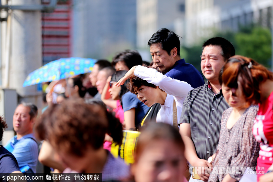 可憐天下父母心 沈陽(yáng)考場(chǎng)外家長(zhǎng)頂烈日踩廢棄電線桿翹首以盼