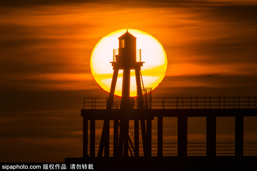 英國(guó)惠特比碼頭日出風(fēng)光 燈塔影影綽綽景色美